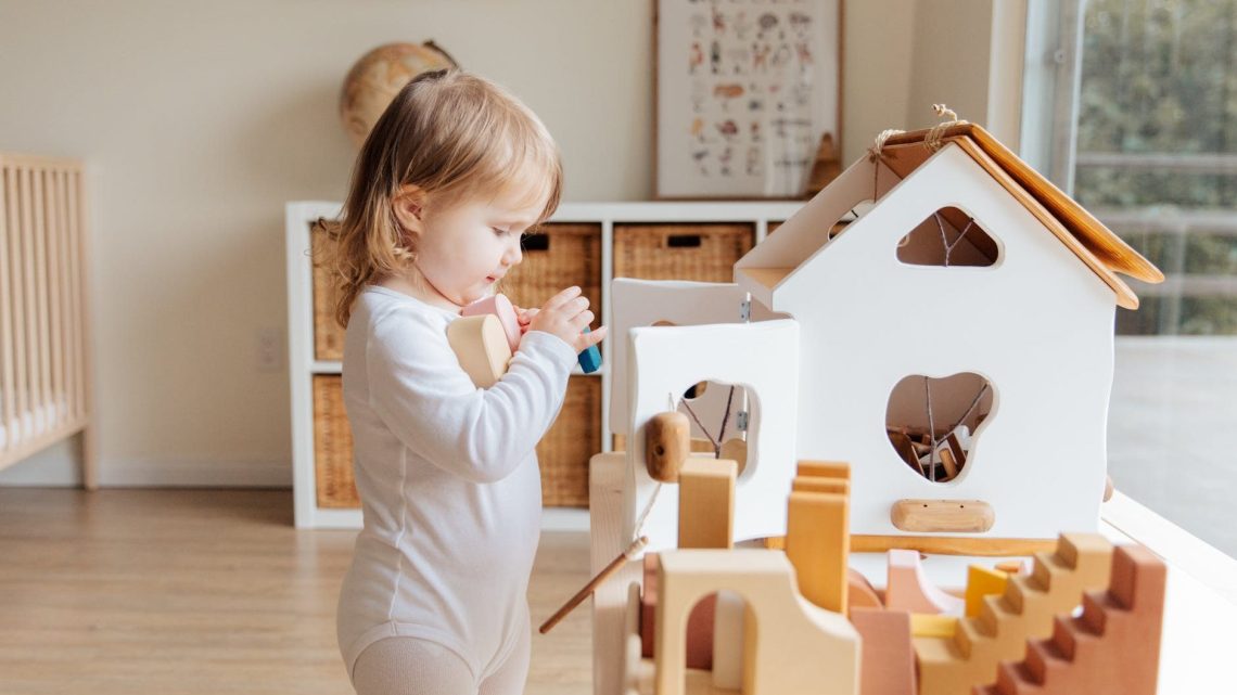 photo of child holding wooden blocks